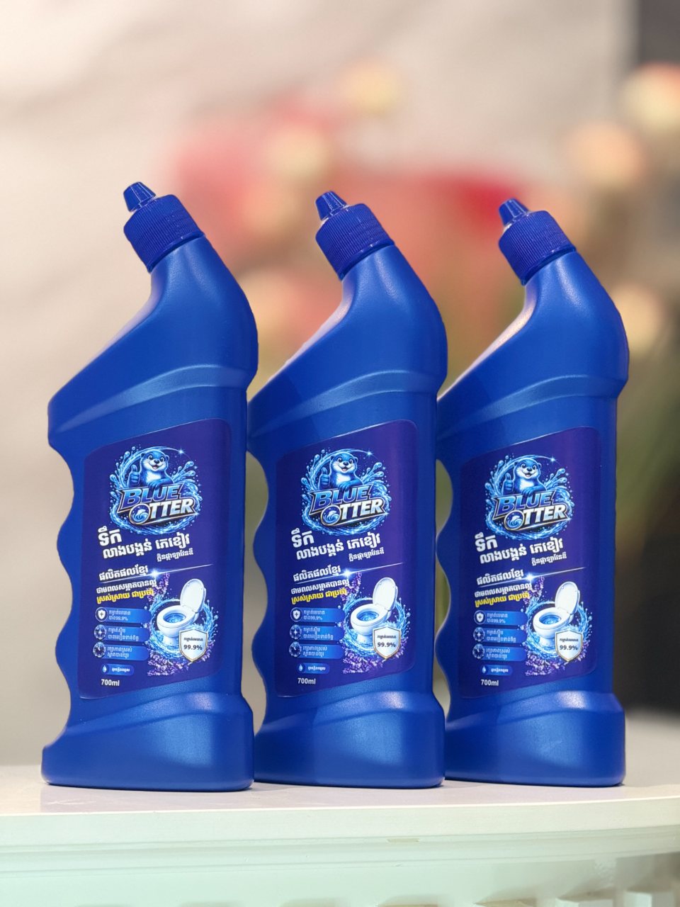 Three 700ml BLUE OTTER Toilet Bowl Cleaner bottles lined up on a white counter